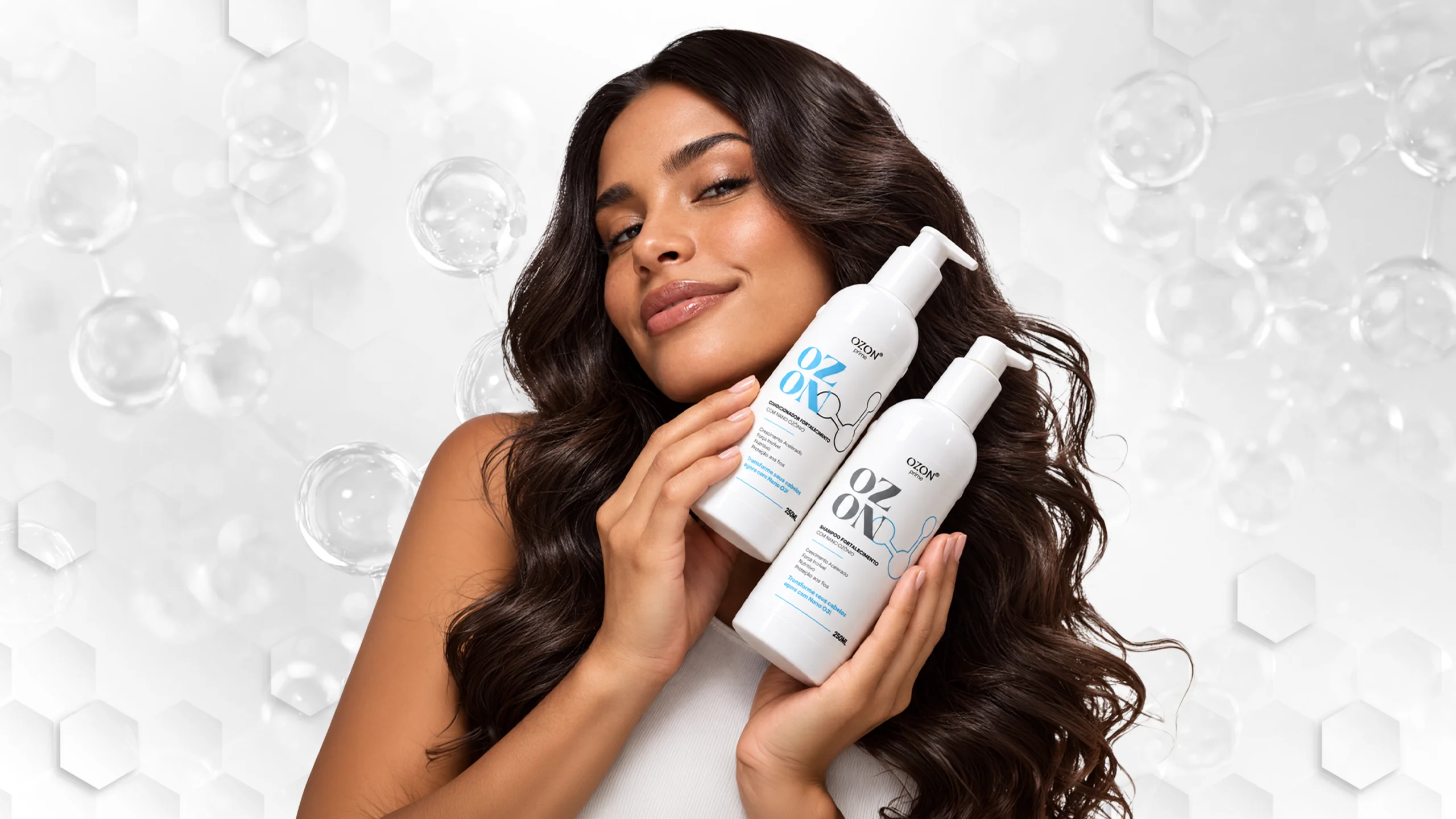 Mulher de cabelos longos e ondulados segurando o Shampoo e o Condicionador Ozon Prime, voltados ao cuidado do couro cabeludo e dos fios